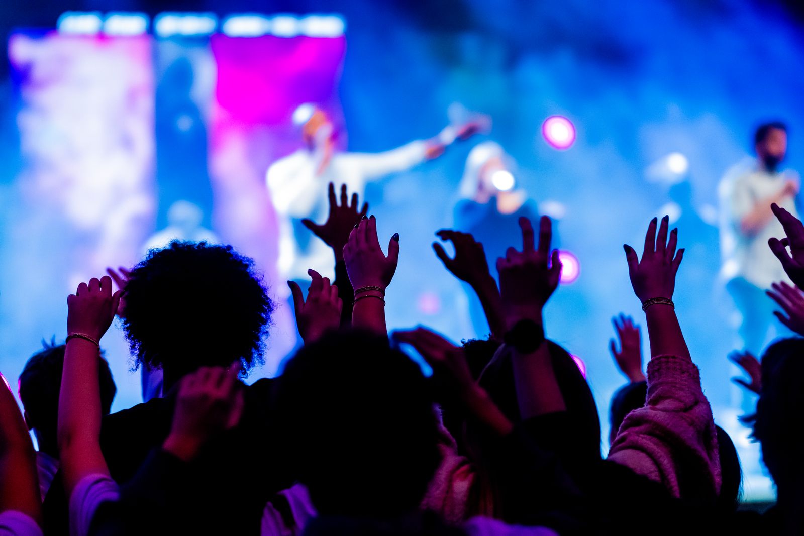 A congregation worshipping together with hands raised
